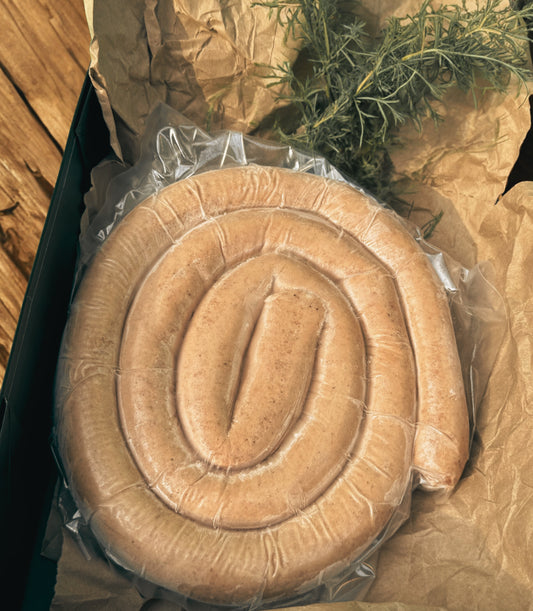 Heritage pork sausage coil from The MF Farmstead in Carrollton, Georgia, pasture-raised and vacuum-sealed with rustic packaging and herbs.