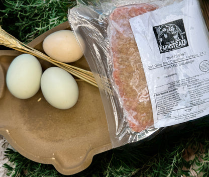 Farm-fresh pork mild sausage from The MF Farmstead in Carrollton, Georgia, packaged beside pasture eggs and wheat on a rustic background.